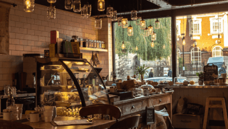 A picture of a modern, cosy cafe with lighting and refrigeration units.