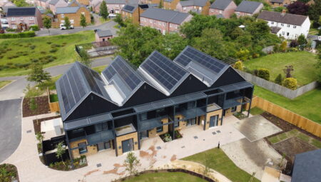 A modern housing complex with solar panels on the roof.