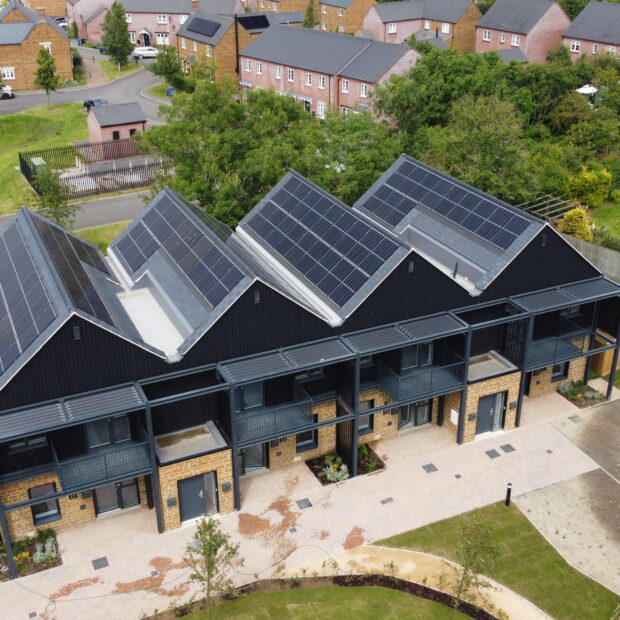 A modern housing complex with solar panels on the roof.
