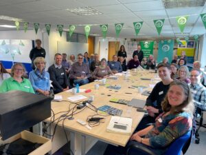 A large group of people around a table discussing community energy.