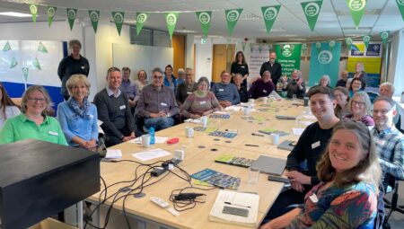 A large group of people around a table discussing community energy.