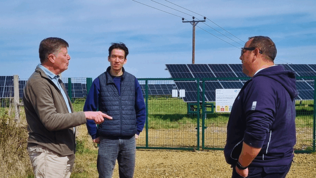 Tristan Turner, Electrical Apprentice Engineer at Low Carbon Hub, standing with the operations team at a solar park.