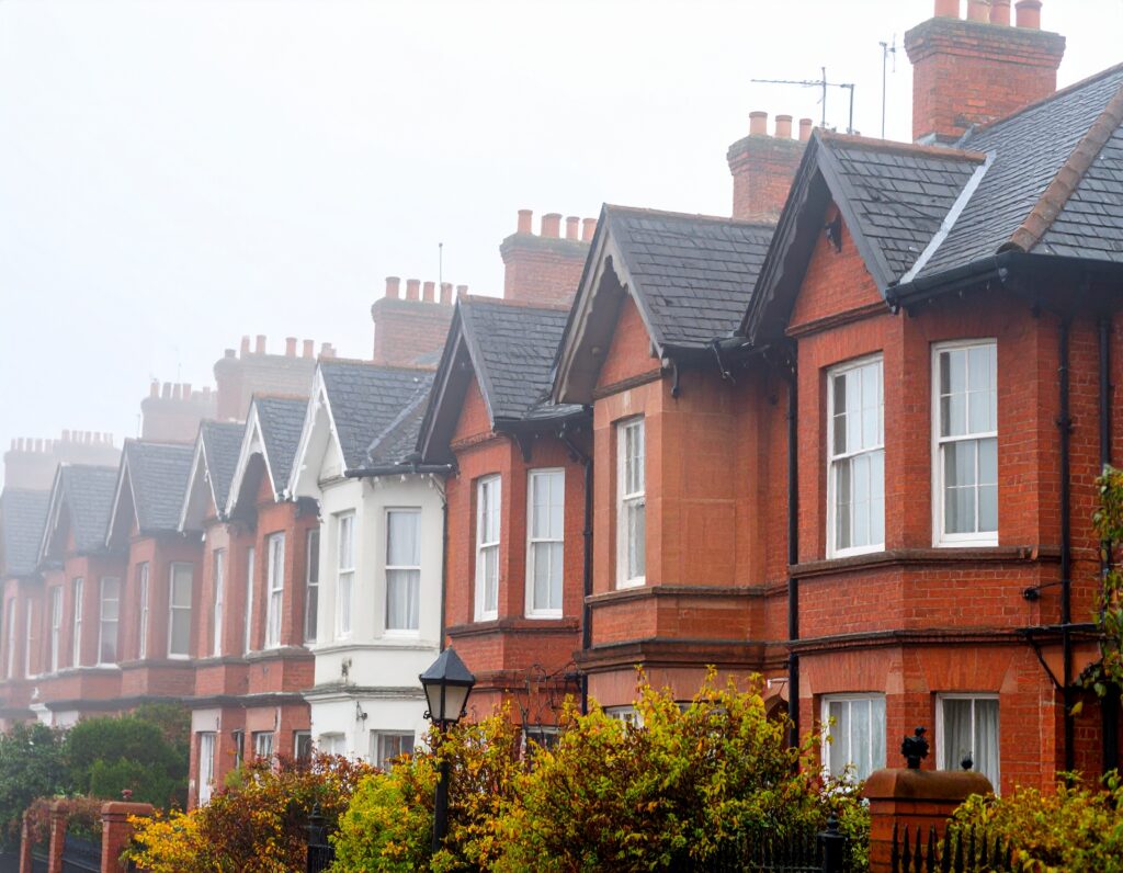Row of Victorian terraced houses in England, slightly out of focus but still recognisable, with traditional brick walls, sash windows, and slate roofs.
