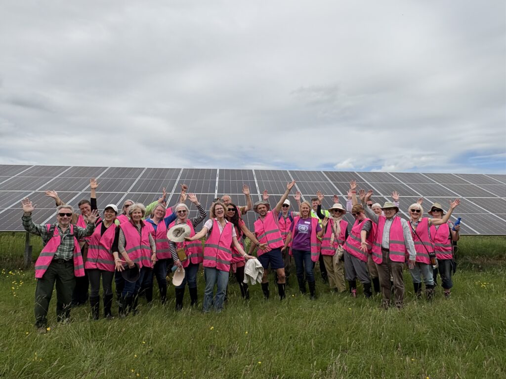 Picture of group of happy people in front of ground mount solar panels at Ray Valley Solar. 